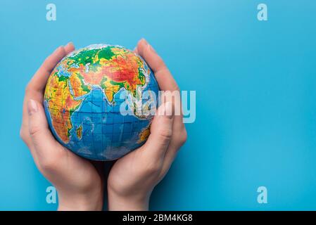 Sparen Sie den Planeten Konzept. Nahaufnahme Foto einer Frau, die Planeten auf einem blauen Hintergrund mit leeren leeren leeren Kopie Raum für Text hält Stockfoto