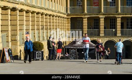 Historische Piece Hall Innenhof Attraktion (Besucher entspannen in sonnigen piazza, zu Fuß durch Cafés und Kolonnaden) - Halifax, West Yorkshire, England, Großbritannien. Stockfoto