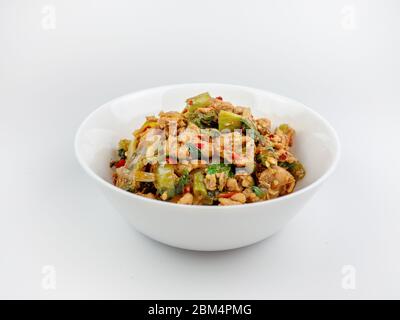 Gebratenes Hähnchen mit heiligem Basilikum auf weißem Hintergrund., scharf und scharf Stockfoto