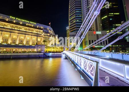 Singapur 30. Dezember 2019 : Cavenagh Bridge bei Nacht, im Hintergrund das Fullerton Hotel Stockfoto