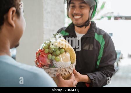 Porträt der asiatischen Lieferung Mann liefern Obst Paket Stockfoto