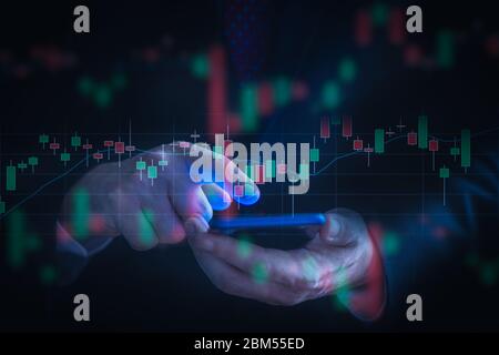 Geschäftsmann prüft Börsendaten mit einem Handy. Analyse Ökonomie und Marktdatenanalyse Konzept. Stockfoto
