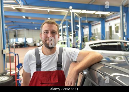 Porträt eines lächelnden Automechanikers in einer professionellen Werkstatt - Nahaufnahme Foto Stockfoto
