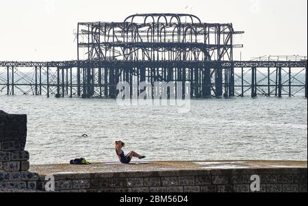 Brighton UK 7. Mai 2020 - EINE junge Frau übt an einem schönen sonnigen Morgen während der Coronavirus COVID-19 Pandemie-Krise am West Pier an der Strandpromenade von Brighton. Das Wetter wird in den nächsten Tagen voraussichtlich heiß und sonnig sein, bevor es am Wochenende kühler wird. Quelle: Simon Dack / Alamy Live News