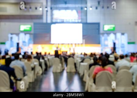 Verschwommene Sicht von hinten aus hörte das Publikum auf die Rede des Redners im Seminar im Gebäude auf verschwommenem Hintergrund. Stockfoto