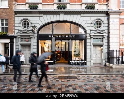 Burberry Store, Covent Garden. An einem regnerischen Tag spazieren die Shopper an der façade zum führenden Modegeschäft im Londoner Modeviertel West End. Stockfoto