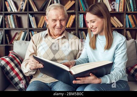 Vater und Tochter zu Hause Bibliothek sitzen Buch lesen fröhlich Stockfoto