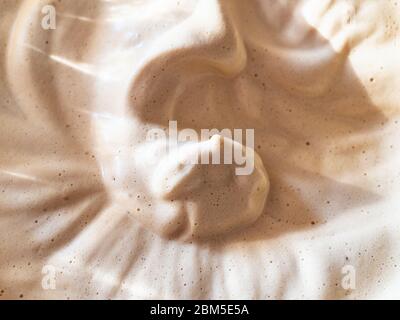 Oberfläche von frisch geschlagenen Dalgona Kaffee (koreanisches Getränk durch Schlagpulver, Zucker und heißem Wasser) aus nächster Nähe Stockfoto