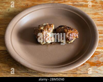 Zwei gebratene russische Kotleta (panierte Hacksteaks) auf Keramikplatte auf einem alten Holztisch in der Küche Stockfoto