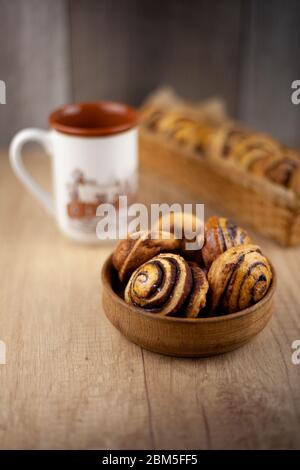 Runde hausgemachte Kekse auf dem Tisch. Gestreifte Plätzchen mit Kakao und Zimt. Leckere Brötchen für eine Tasse Kaffee zum Frühstück. Holzhintergrund innen Stockfoto