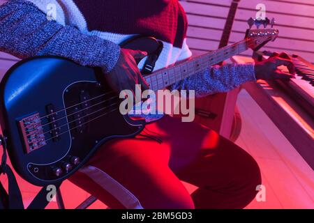 Erstellen Sie Musik und ein Aufnahmestudio-Konzept - African american man Gitarrist Aufnahme E-Bass Gitarre Track im Home Studio, close-up. Stockfoto