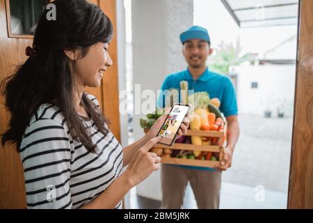 Lebensmittelgeschäft Bestellung über Smartphone-Apps. Nahaufnahme Hand halten Smartphone und kaufen etwas Essen online Stockfoto