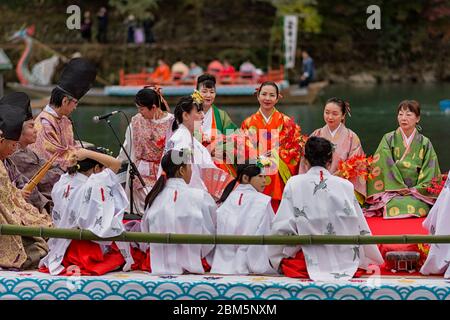 Kyoto / Japan - 12. November 2017: Traditionelle Bootsfahrt auf dem Katsura River, in der Nähe des Arashiyama Parks in Kyoto, Japan. Menschen kleiden sich in traditioneller Kleidung, Stockfoto