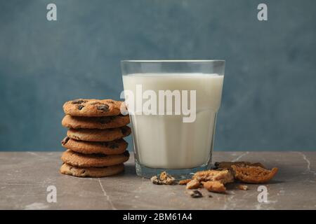 Chocolate Chip Cookies und ein Glas Milch auf einem braunen Tisch Stockfoto