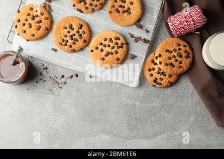 Zusammensetzung mit Chip Cookies und Karamell auf grauem Tisch Stockfoto