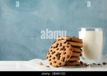 Zusammensetzung mit Chip Cookies, Milch und Karamell auf weißem Holztisch Stockfoto