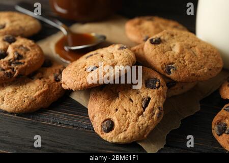 Zusammensetzung mit Chip Cookies, Milch und Karamell auf Holztisch Stockfoto