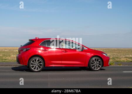 2020 Red Toyota Corolla Excel HEV CVT; Fahrzeugverkehr Moving Vehicles, Driving Vehicle auf UK Straßen, Motoren, Autofahren auf der Küstenstraße in Southport, Merseyside, UK Stockfoto