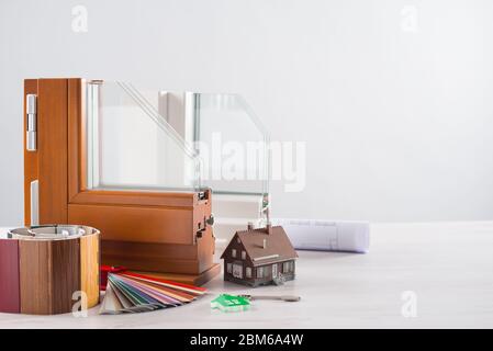 Windows-Abschnitt mit dreifach-Verglasung und hölzernen Rahmen, Rollläden Farbfelder, Hausmodell und Schlüssel, Renovierungs-Konzept Stockfoto