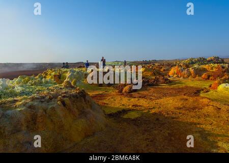Dallol, Äthiopien - Nov 2018: Touristen, die durch die bunte Landschaft des terrestrischen Dallol-Hydrothermalsystems in der Danakil-Wüste, Äthiopien, reisen Stockfoto