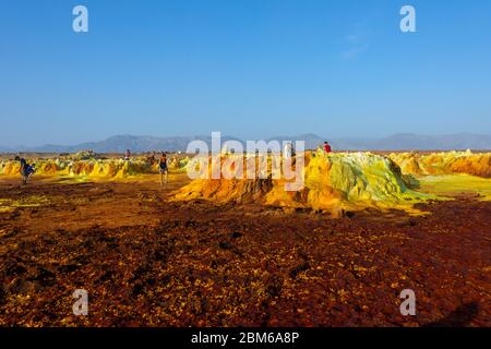 Dallol, Äthiopien - Nov 2018: Touristen, die durch die bunte Landschaft des terrestrischen Dallol-Hydrothermalsystems in der Danakil-Wüste, Äthiopien, reisen Stockfoto