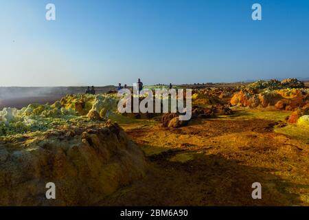 Dallol, Äthiopien - Nov 2018: Touristen, die durch die bunte Landschaft des terrestrischen Dallol-Hydrothermalsystems in der Danakil-Wüste, Äthiopien, reisen Stockfoto