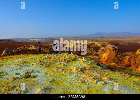 Dallol, Äthiopien - Nov 2018: Touristen, die durch die bunte Landschaft des terrestrischen Dallol-Hydrothermalsystems in der Danakil-Wüste, Äthiopien, reisen Stockfoto