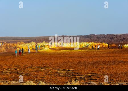 Dallol, Äthiopien - Nov 2018: Touristen, die durch die bunte Landschaft des terrestrischen Dallol-Hydrothermalsystems in der Danakil-Wüste, Äthiopien, reisen Stockfoto