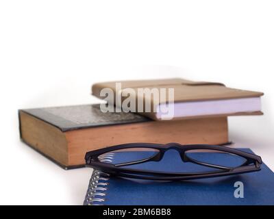 Nahaufnahme von Gläsern und Büchern, auf einem weißen Hintergrund Stockfoto