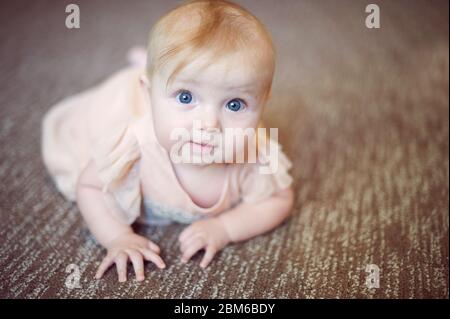 Porträt eines süßen Säuglings Baby Mädchen trägt ein rosa Kleid im Studio Stockfoto