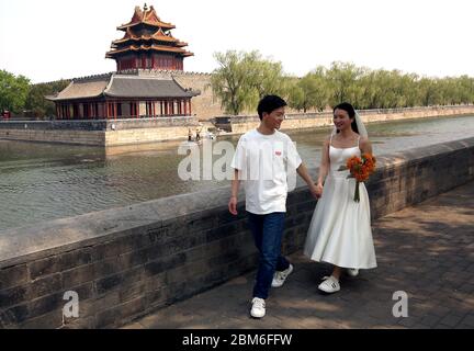Peking, China. Mai 2020. Chinesische Jungvermählte lassen ihre Fotos am Rande der Verbotenen Stadt machen, nachdem die Regierung am Donnerstag, den 7. Mai 2020, die Bedrohung von Covid-19 auf Stufe 2 in Peking herabgesetzt hatte. Trotz der Lockerung der Selbstquarantänemaßnahmen in der Hauptstadt sind die meisten großen touristischen Gebiete für die Öffentlichkeit und Ausländer geschlossen. Es sind spezielle Pässe erforderlich, die nur schwer zu erhalten sind. Foto von Stephen Shaver/UPI Quelle: UPI/Alamy Live News Stockfoto