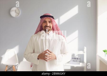 Nachdenklicher arabischer Mann schaut aus dem Fenster in einem weißen Büro Stockfoto