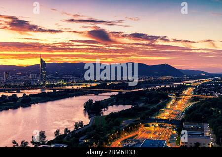 Wien bei Sonnenuntergang mit Donau, Autobahn Nr. A22 Kreuzung und einer der interessantesten umfangreichen öffentlichen Erholungsgebiet genannt Donauinsel Stockfoto