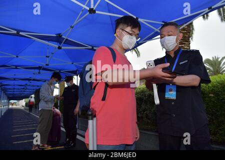 Nanchang, Chinas Provinz Jiangxi. Mai 2020. Ein Student wird am 7. Mai 2020 seine Temperatur prüfen, bevor er die Nanchang Universität in Nanchang, der ostchinesischen Provinz Jiangxi, betritt. Studenten der Nanchang Universität begannen am Donnerstag, zur Schule zurückzukehren. Die Universität hat verschiedene Maßnahmen zur Prävention von Epidemien auf dem Campus getroffen, um die Sicherheit der Studierenden zu gewährleisten. Kredit: Peng Zhaozhi/Xinhua/Alamy Live News Stockfoto