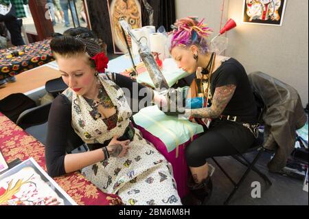 Frau, die auf der London Tattoo Convention, Tobacco Dock, 50 Porters Walk, London, Großbritannien tätowiert wird. 26 Sept. 2009 Stockfoto