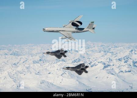 Eine E-3 Sentry und zwei F-22 Raptors, die der Joint Base Elmendorf-Richardson (JBER) in Anchorage, Alaska, zugewiesen sind, fliegen über Berge im Staat 5. Mai 2020. Das Flugzeug war Teil eines Formationsfluges, der die Luftkraft in Alaska demonstrierte und bestand aus aktiven Dienst-, Wache- und Reservekomponenten mit Sitz in JBER. (USA Air Force Foto von Tech. Sgt. Jerilyn Quintanilla) Stockfoto