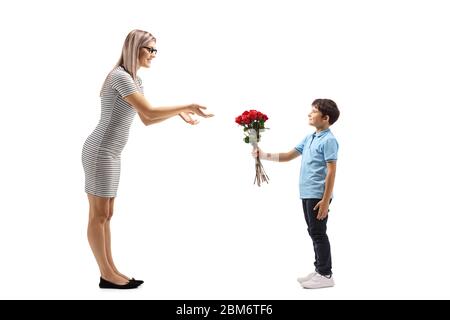 In voller Länge Profil Aufnahme eines Jungen geben einen Haufen roter Rosen zu einer jungen Frau isoliert auf weißem Hintergrund Stockfoto