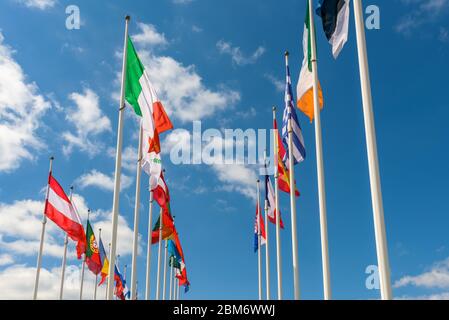 Flaggen der EU-Mitgliedstaaten, die vor dem Gerichtshof in Luxemburg-Stadt im Wind gegen einen blauen Himmel mit weißen Wolken wehen. Stockfoto