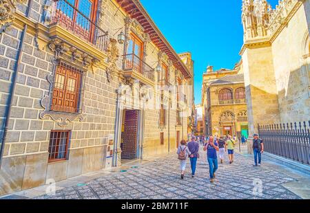 GRANADA, SPANIEN - 27. SEPTEMBER 2019: Touristen gehen in der Calle Oficios (La Lonja Platz), gesäumt von historischen Gebäuden der Capilla Real (Königliche Kapelle) an Stockfoto