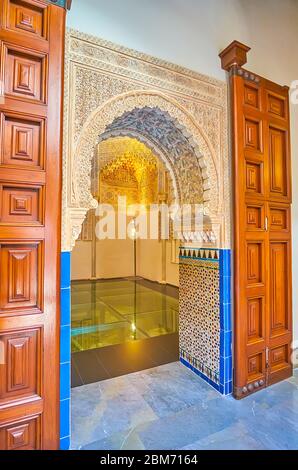 GRANADA, SPANIEN - 27. SEPTEMBER 2019: Traditionelles Hufeisenportal zur Moschee des Palacio de la Madraza (Madrasa), dekoriert mit Sebka und feinen Ti Stockfoto