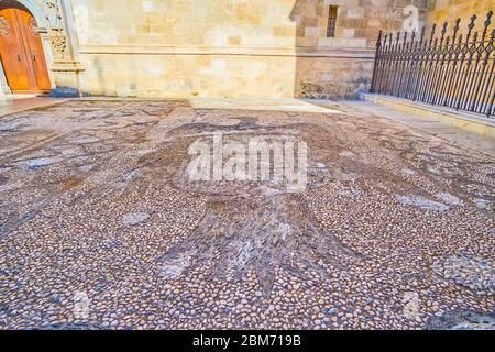 GRANADA, SPANIEN - 27. SEPTEMBER 2019: Der Steinboden an der Wand der Capilla Real (Königliche Kapelle) ist mit dem spanischen Emblem, Calle Oficios (La Lo Stockfoto