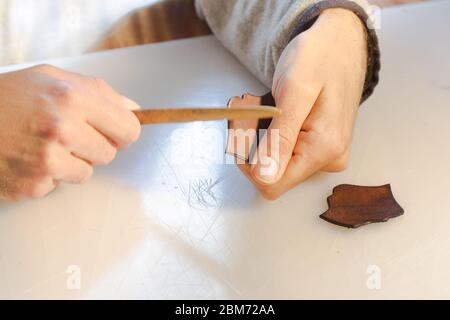 Lederrand Burnishing, Lederrand Finishing von handgefertigten Werkzeugen. Der Prozess der Herstellung einer Ledertasche handgefertigt. Der Handwerker näht ein Leder Stockfoto