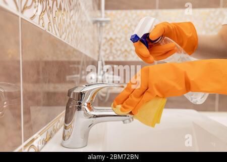 Reinigung des Wasserhahnes von Kalk im Bad, Desinfektion der Oberfläche von Verschmutzung. Stockfoto