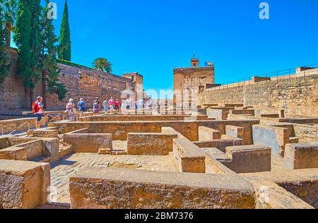 GRANADA, SPANIEN - 25. SEPTEMBER 2019: Eine Gruppe von Touristen geht durch die Ruinen der Plaza de Armas (Waffenplatz) von Alcazaba mit Blick auf den Wachturm Stockfoto