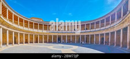 GRANADA, SPANIEN - 25. SEPTEMBER 2019: Panorama des Carlos V Palastes der Alhambra mit kreisförmigem Patio und zweistöckiger Terrasse mit mehreren Steinsäulen, auf Stockfoto