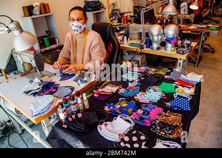 Ein Schneider näht Gesichtsmasken aus verschiedenen Stoffen und trägt dabei eine Gesichtsmaske als vorbeugende Maßnahme gegen die Ausbreitung des Coronavirus (COVID-19).ab dem 1. Juni müssen Masken in öffentlichen Verkehrsmitteln getragen werden. In einer Nähwerkstatt stellt Aladdin einzigartige Masken mit eigenem Design und verschiedenen Stoffen her. Stockfoto