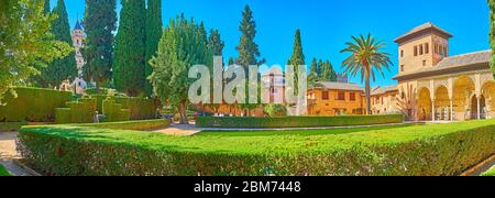 GRANADA, SPANIEN - 25. SEPTEMBER 2019: Panorama vom dekorativen Partalgarten mit Blick auf üppiges Grün, Ziersträucher, Partalpalastportikus an Stockfoto