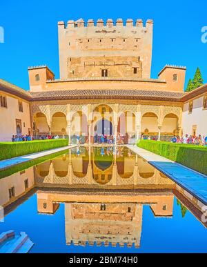 GRANADA, SPANIEN - 25. SEPTEMBER 2019: Das Äußere des Palastes und des Turms von Comares (Nasriden-Palast, Alhambra) und seine Spiegelung im klaren Wasser des Teiches Stockfoto