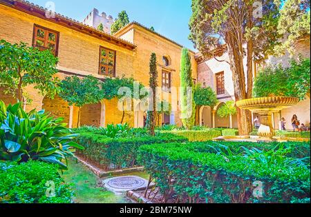 GRANADA, SPANIEN - 25. SEPTEMBER 2019: Der üppige und schattige Garten des Nasriden Palastes in der Alhambra ist der perfekte Ort, um sich zu entspannen und den Brunnen zu beobachten Stockfoto