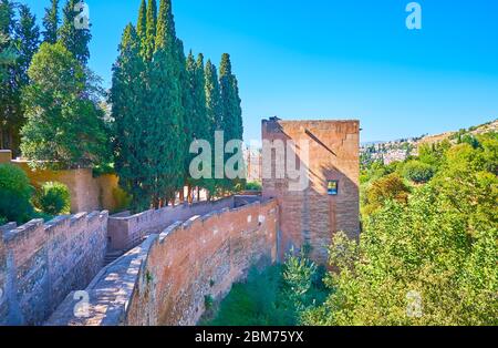 Die mittelalterliche Backsteinmauer und der Turm der Captive der Alhambra Festung ist von üppigem Grün umgeben, Granada, Spanien Stockfoto